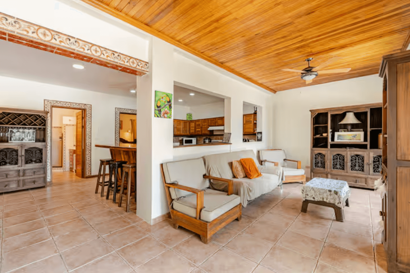 A bright and welcoming living room with comfortable seating, wooden accents, and a relaxed tropical vibe, perfect for unwinding after a day of adventure.