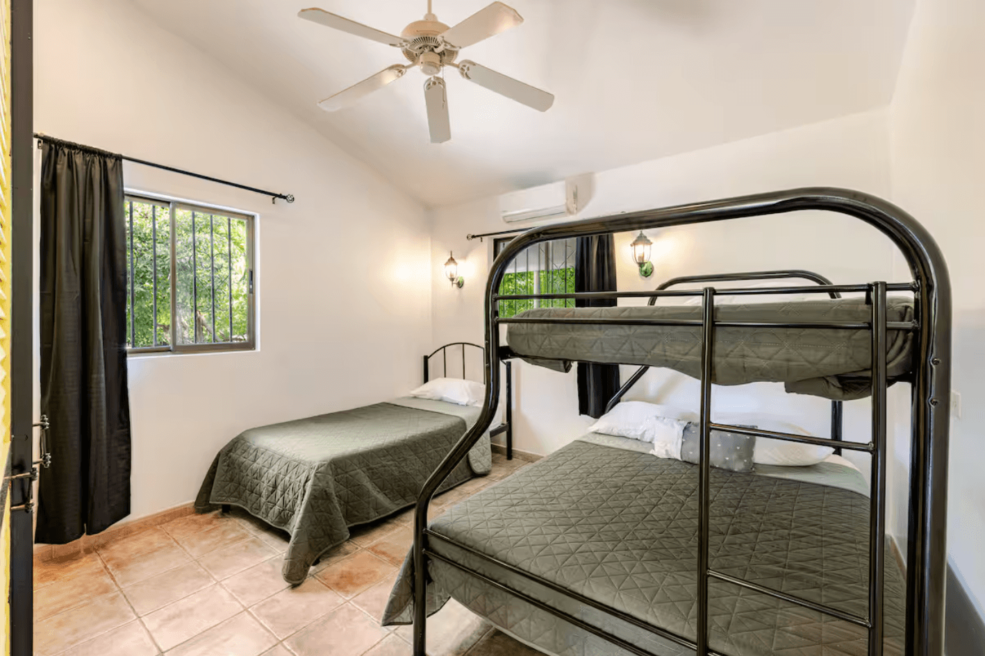 A practical and spacious room with bunk beds and large windows opening onto the tropical garden, ideal for families or groups wanting comfort and flexibility.