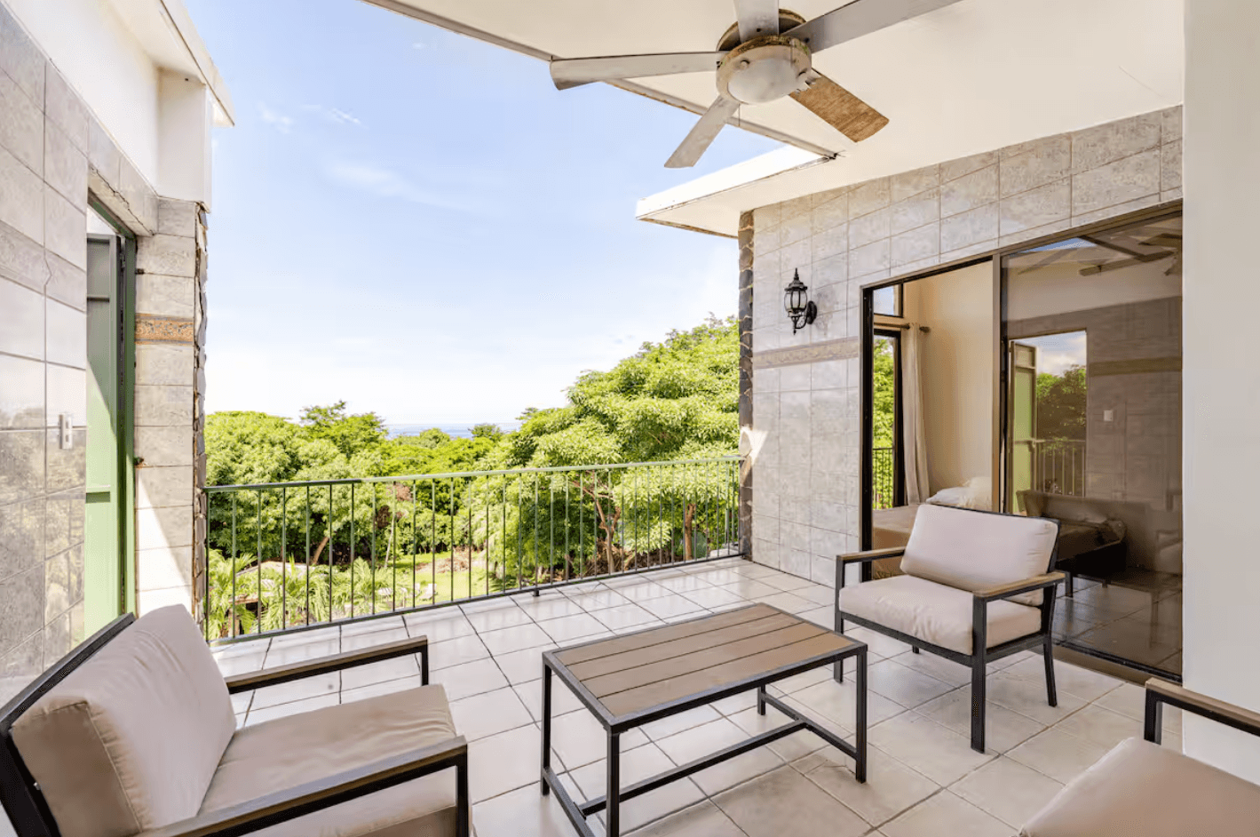 A stylish, sun-filled room with comfortable seating and beautiful views of the tropical landscape, a serene retreat for nature lovers.