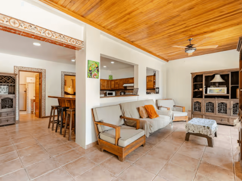 A bright and welcoming living room with comfortable seating, wooden accents, and a relaxed tropical vibe, perfect for unwinding after a day of adventure.