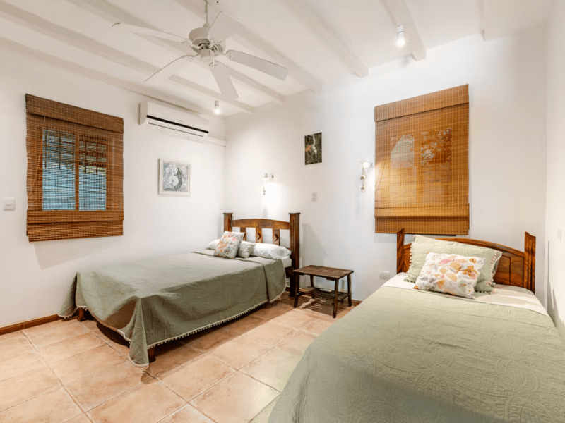 A bright double room designed for peaceful nights, blending handcrafted wood, soft linens, and cool mountain air drifting through the windows.