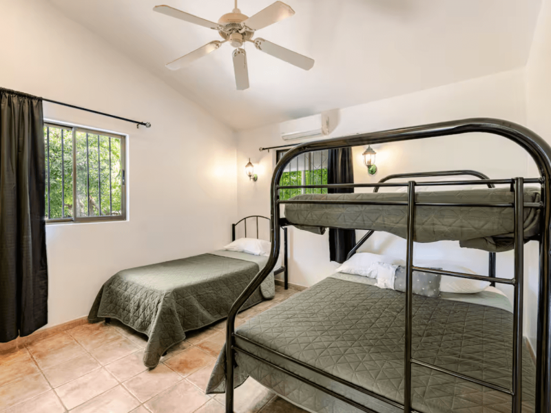 A practical and spacious room with bunk beds and large windows opening onto the tropical garden, ideal for families or groups wanting comfort and flexibility.